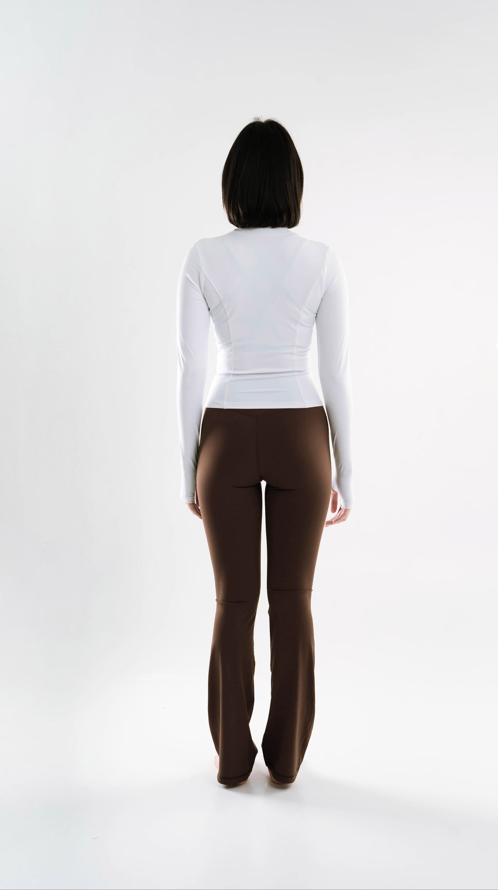 Person wearing a Shanti Jacket Icon Indonesia top and brown pants on a white background