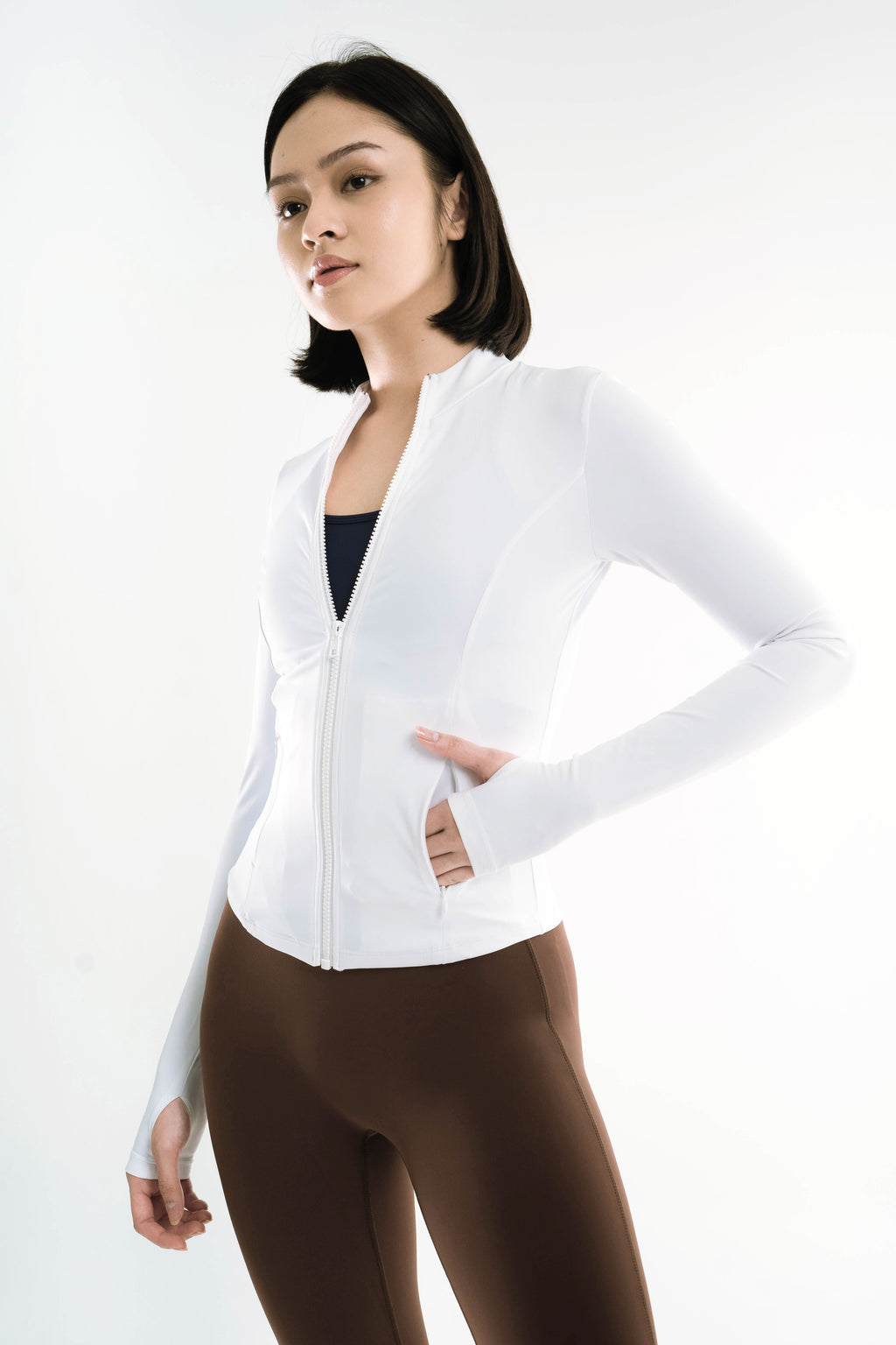 Woman wearing a white blazer over a black top on a white background