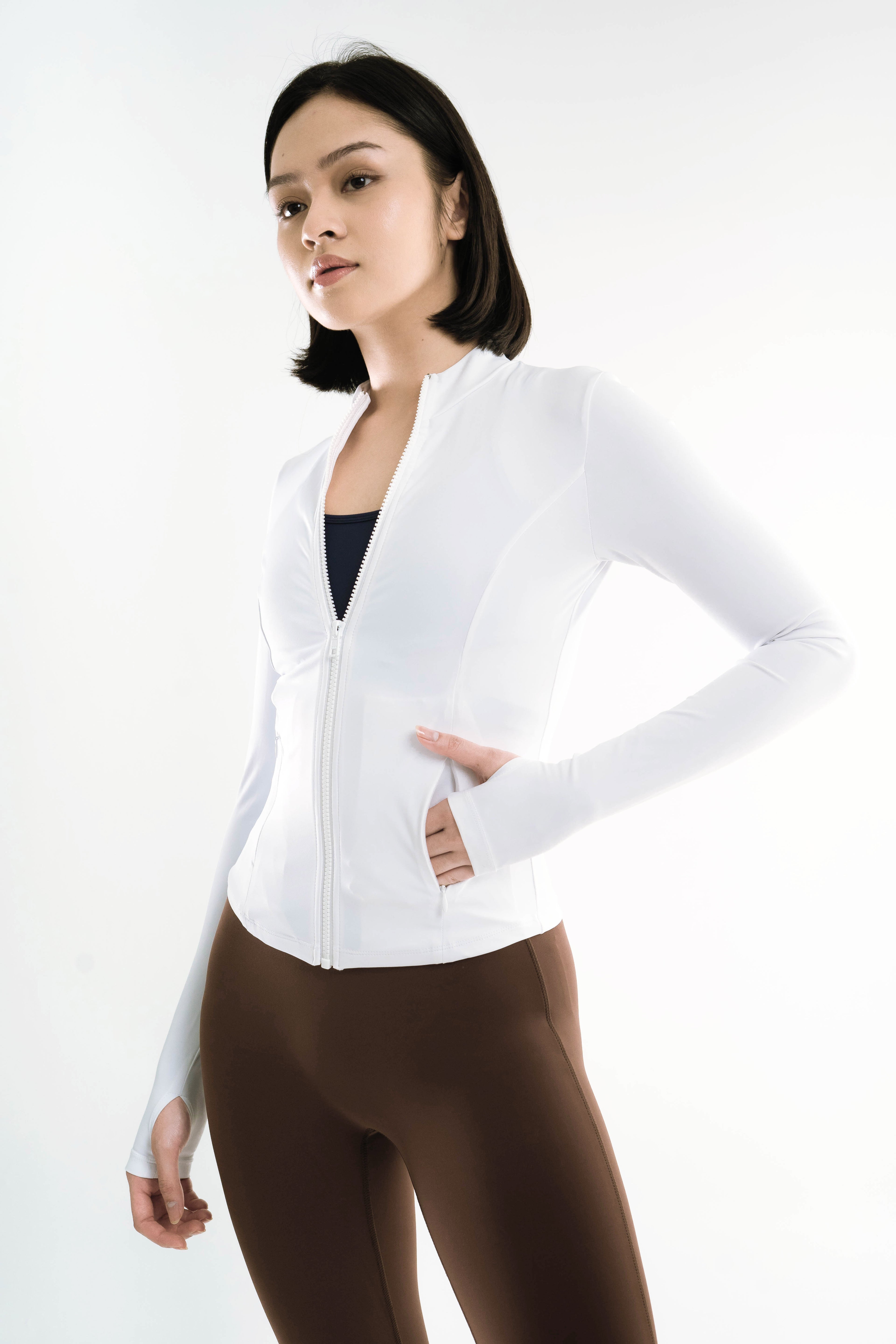 Woman wearing a white blazer over a black top on a white background