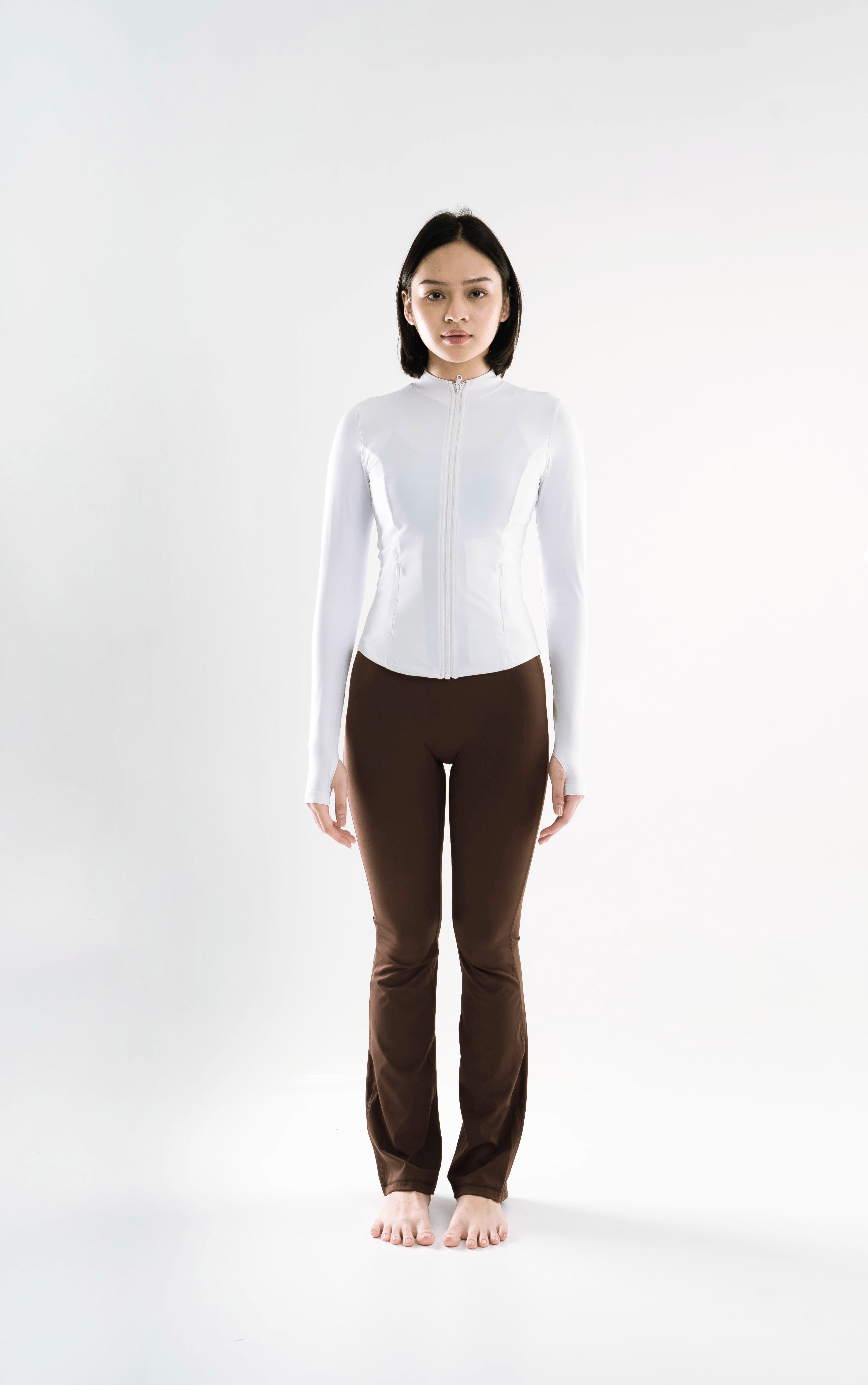 Person wearing a Shanti Jacket Front ICON INDONESIA white long-sleeve top and brown pants on a white background